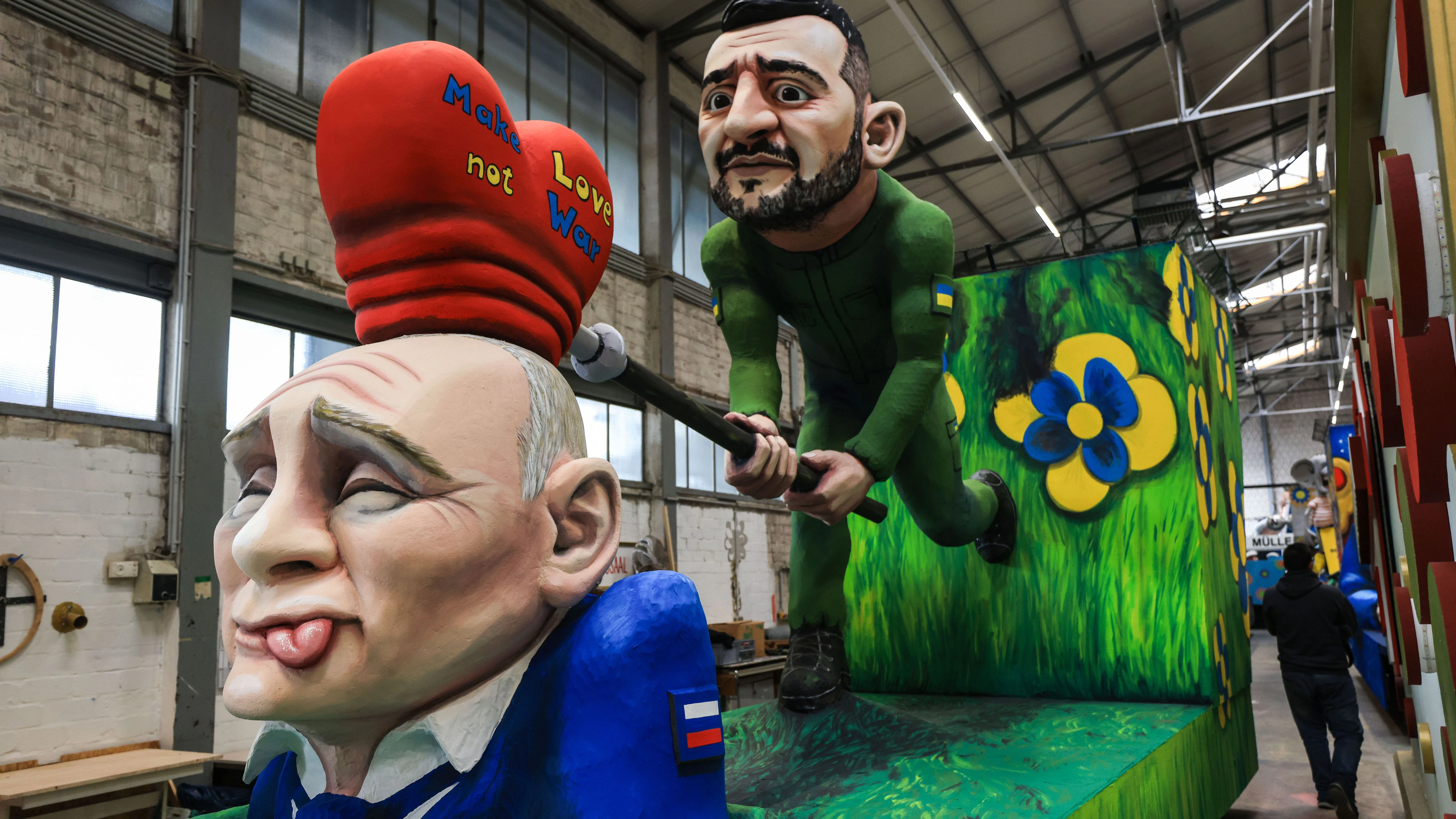 Der ukrainische Präsident Wolodymyr Selenskyj versucht dem russischen Präsidenten Wladimir Putin die Botschaft „Make Love not War“ einzuhämmern. Motivwagen des Kölner Rosenmontagszuges