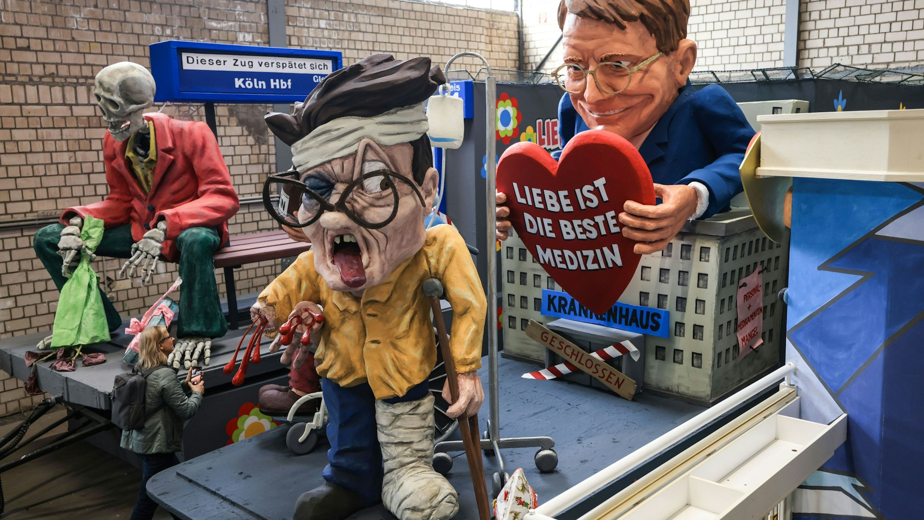 Auf diesem Kölner Motivwagen überbrückt Bundesgesundheitsminister Karl Lauterbach Lieferengpässe bei Medikamenten und Personalmangel im Gesundheitswesen mit dem Rezept „Liebe ist die beste Medizin“ .