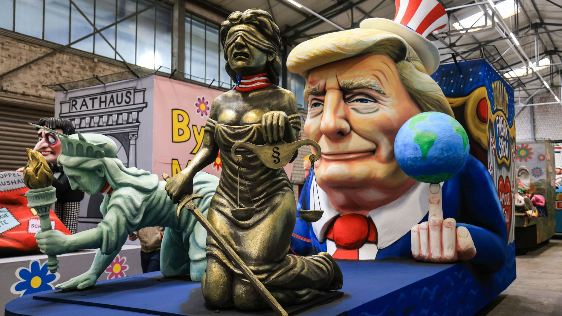 US-Präsident Donald Trump als Zirkusdirektor führt Recht und Freiheit an der Leine, die Welt jongliert er auf dem „Stinkefinger“. Ein Motivwagen des Kölner Rosenmontagszuges in der Wagenhalle.