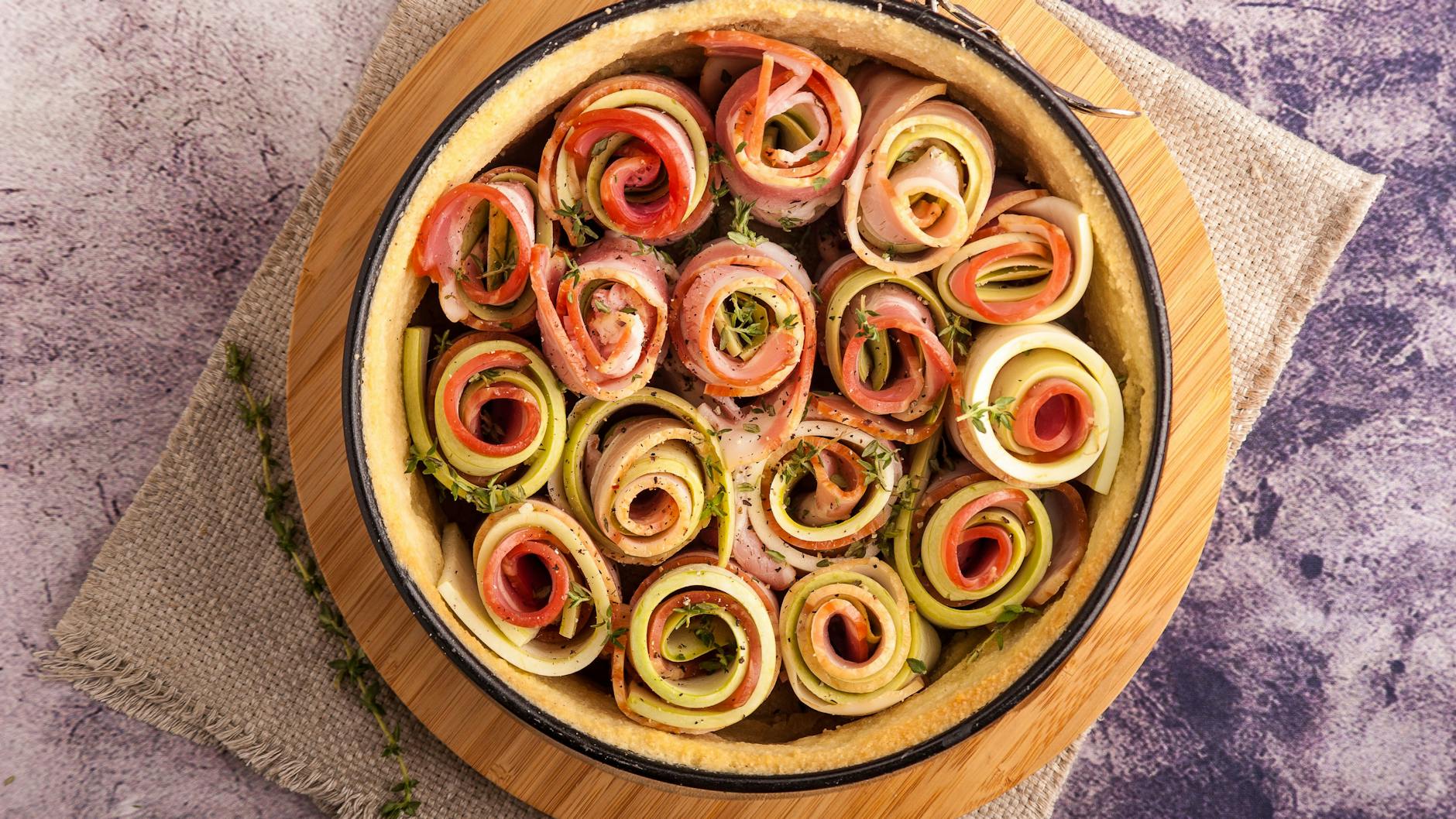 Statt einer großen Spirale kann man auch einzelne Gemüse-Rollen in die Tarte setzen.