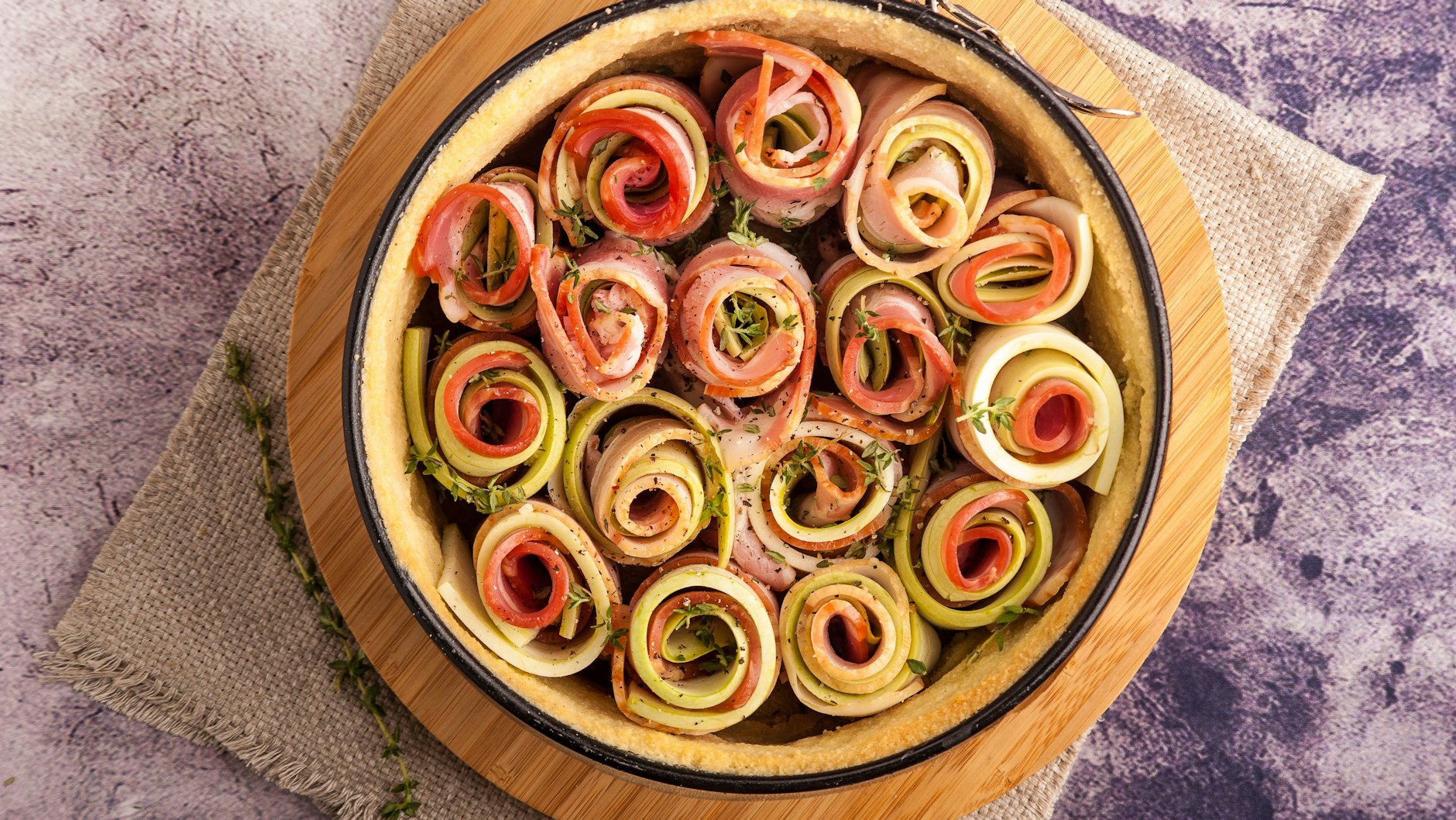 Statt einer großen Spirale kann man auch einzelne Gemüse-Rollen in die Tarte setzen.