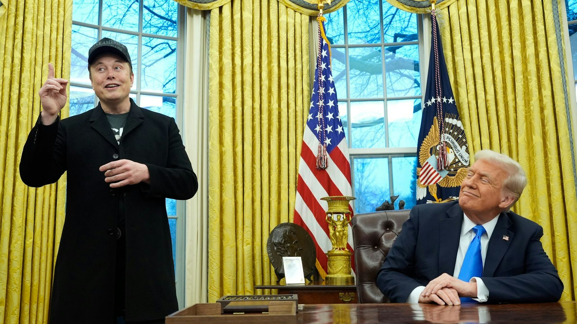 US-Präsident Donald Trump (r) hört zu, als Elon Musk im Oval Office im Weißen Haus spricht.