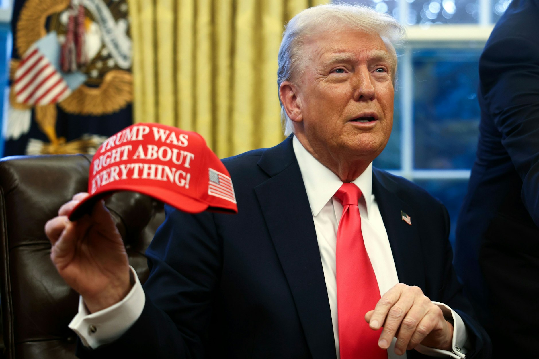 US-Präsident Donald Trump hält eine Kappe mit der Aufschrift „Trump Was Right About Everything“ (deutsch: Trump hatte mit allem recht).