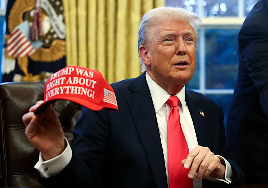 US-Präsident Donald Trump hält eine Kappe mit der Aufschrift „Trump Was Right About Everything“ (deutsch: Trump hatte mit allem recht).