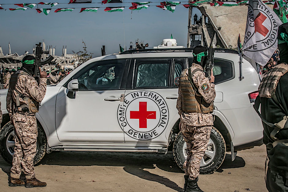 Kämpfer des Islamischen Dschihad und der  Al-Kassam-Brigaden, des militärischen Flügels der Hamas, umringen am 15. Februar ein Auto des Roten Kreuzes während der Übergabe von drei israelischen Geiseln im südlichen Gazastreifen.