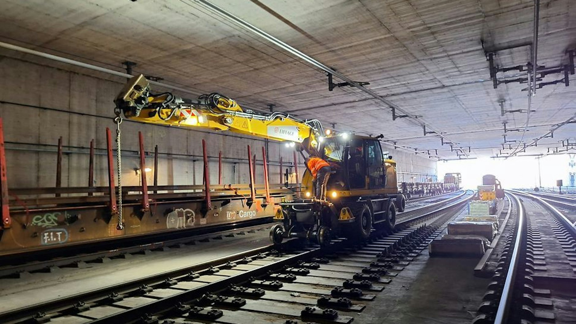 Ein Baustellenfahrzeug arbeitet sich durch einen Bahntunnel.