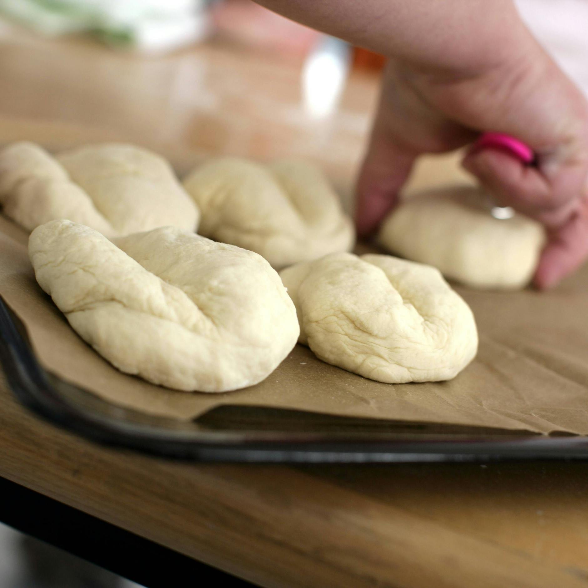 Vor dem Backen werden die Brötchen mit einem scharfen Messer längs eingeschnitten.