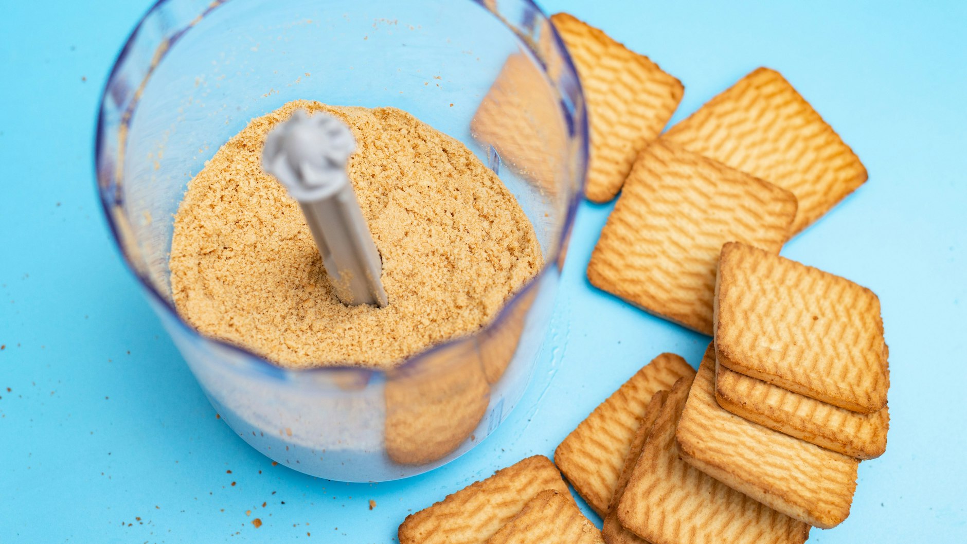 Im Mixer werden aus den Keksen ganz schnell die Brösel für den Kuchenboden. Mit dem Nudelholz klappt das auch gut.
