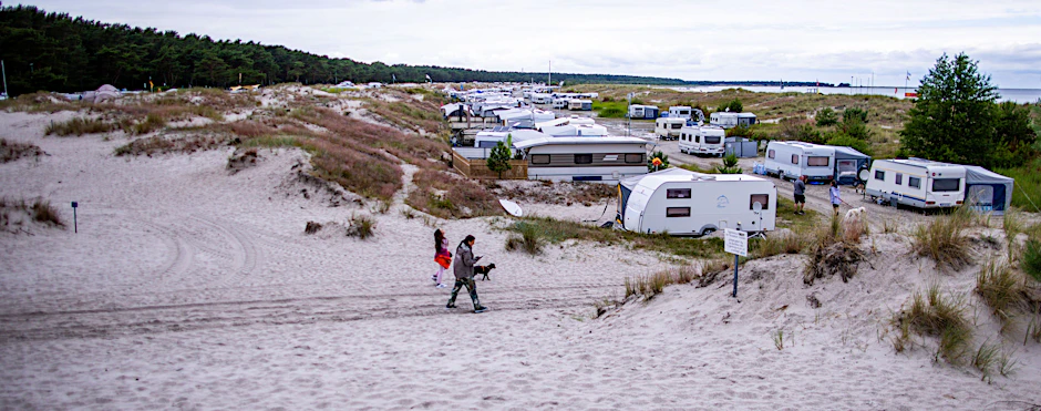 Wohnwagen stehen auf dem Campingplatz Regenbogencamp in den Dünen auf Fischland-Darß-Zingst.