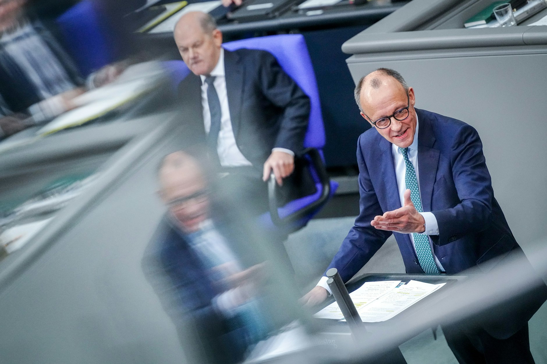 Friedrich Merz (r), CDU-Bundesvorsitzender, spricht im Bundestag neben Kanzler Olaf Scholz (SPD).