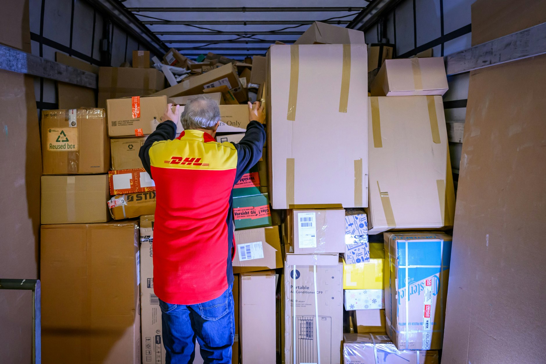 Ein Mitarbeiter bestückt im DHL-Paketzentrum Rüdersdorf (Brandenburg) den Laderaum eines Lkw mit Päckchen und Paketen. Doch oft kommen sie zu spät oder beschädigt an.