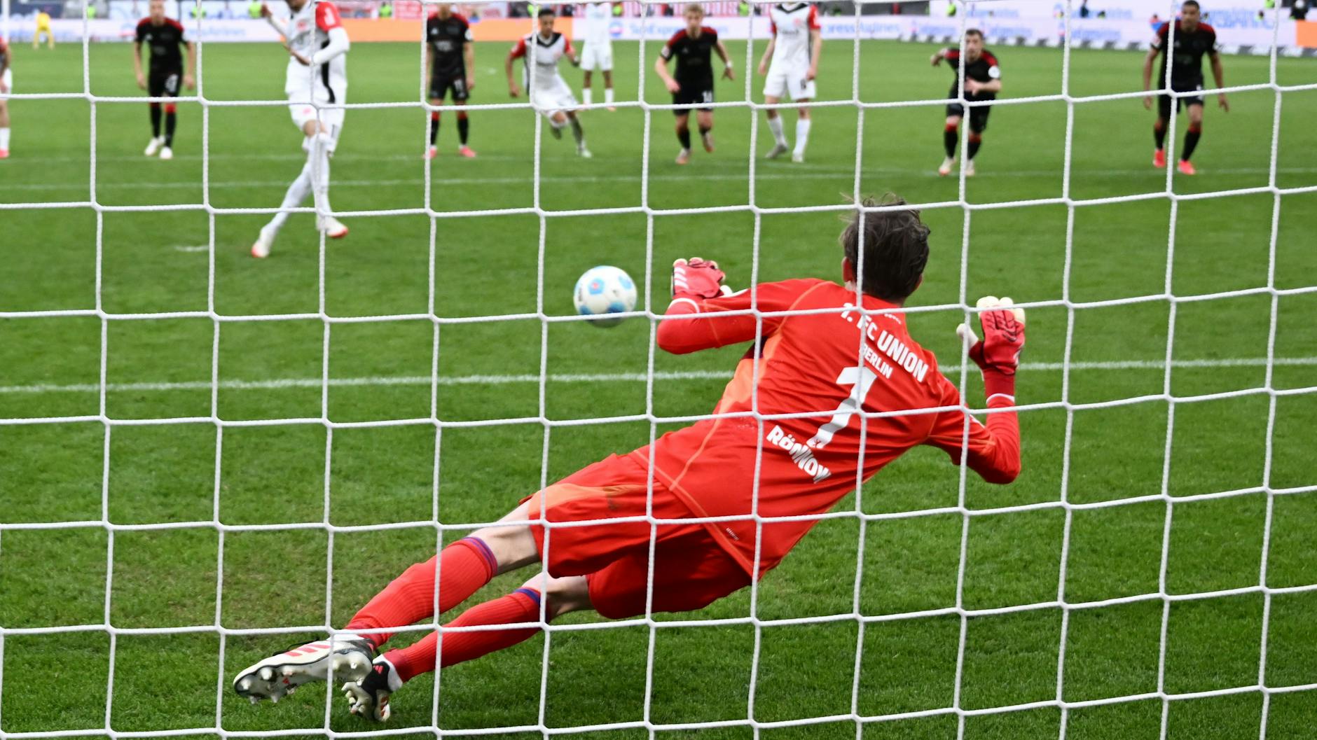 Torwart Frederik Rönnow vom 1. FC Union hält den von Frankfurts Hugo Ekitike geschossenen Elfmeter.