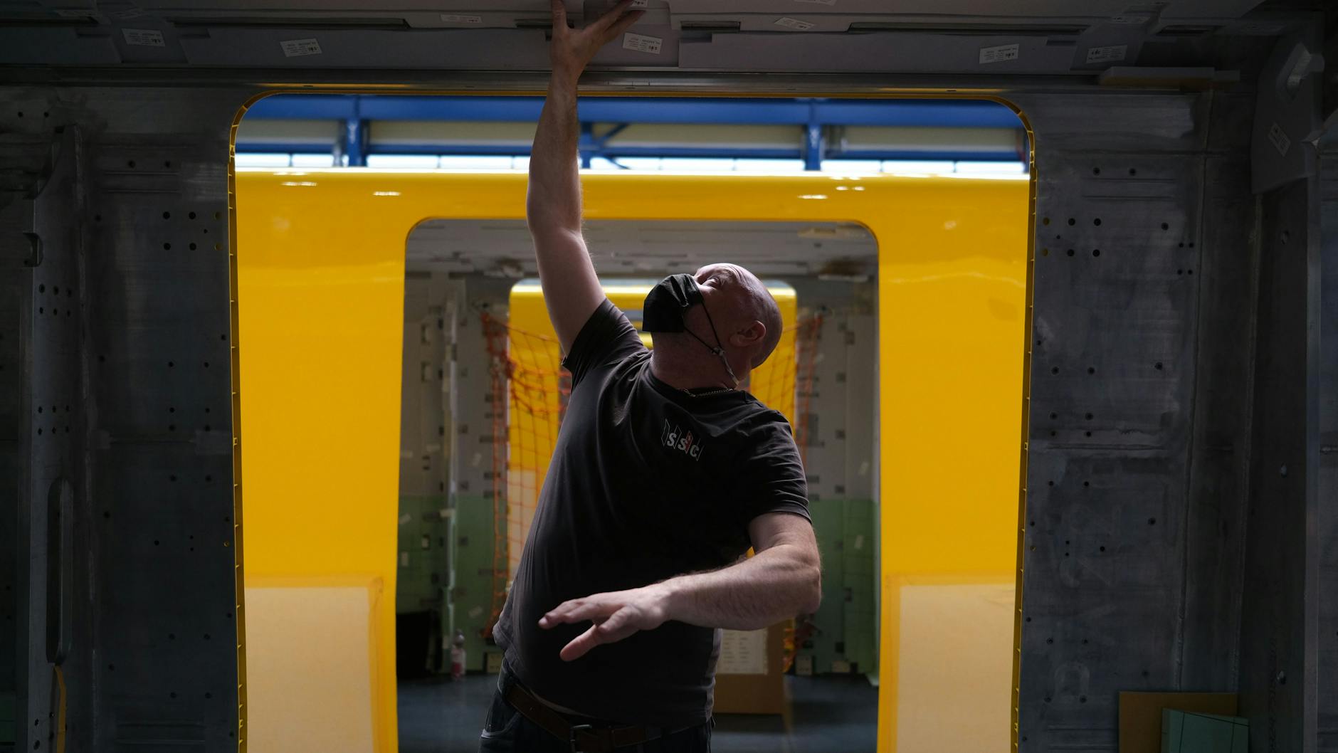 Ein Mitarbeiter hantiert am Abteil eines der neuen U-Bahnzüge aus dem Pankower Stadler-Werk.
