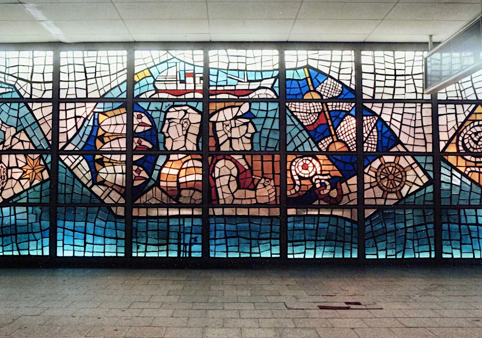 Teil des großen Glasfrieses, der bis 1991 die Fassade vom Gastmahl des Meeres, heute Nordsee an der Ecke Karl-Liebknecht-/Spandauer Straße, bildete. Es verschwand, wurde abgetragen – aber von Arnim Henke erhalten.