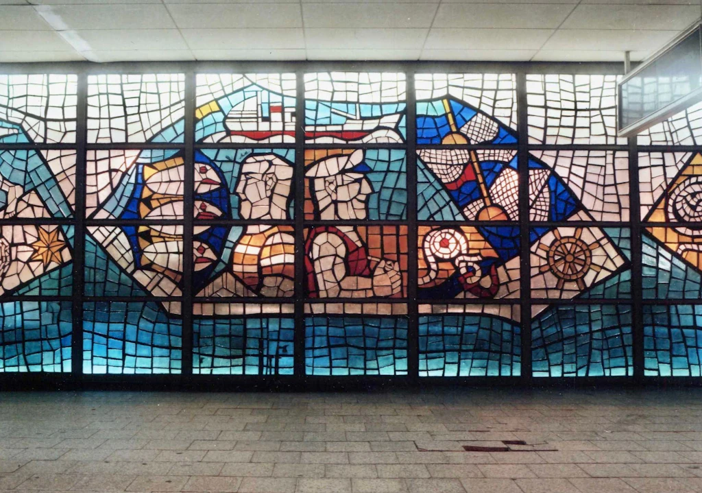 Teil des großen Glasfrieses, der bis 1991 die Fassade vom Gastmahl des Meeres, heute Nordsee an der Ecke Karl-Liebknecht-/Spandauer Straße, bildete. Es verschwand, wurde abgetragen – aber von Arnim Henke erhalten.