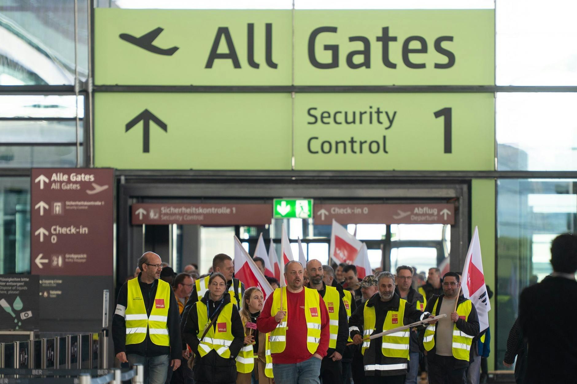 Streikende Flughafenmitarbeiter gehen durch das Terminal am Flughafen Berlin-Brandenburg BER.