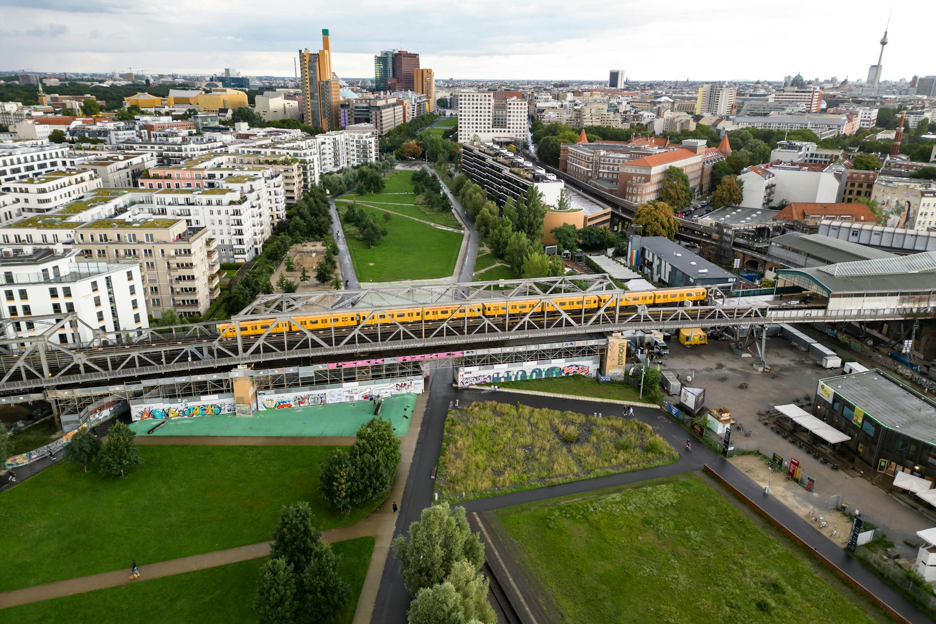 Ein Zug der U1 auf einer Bahnbrücke - Luftaufnahme vom Gleisdreieck Park in Berlin am 8. August 2023.