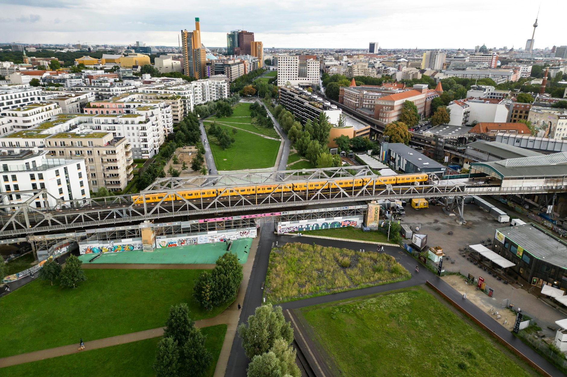 Ein Zug der U1 auf einer Bahnbrücke - Luftaufnahme vom Gleisdreieck Park in Berlin am 8. August 2023.