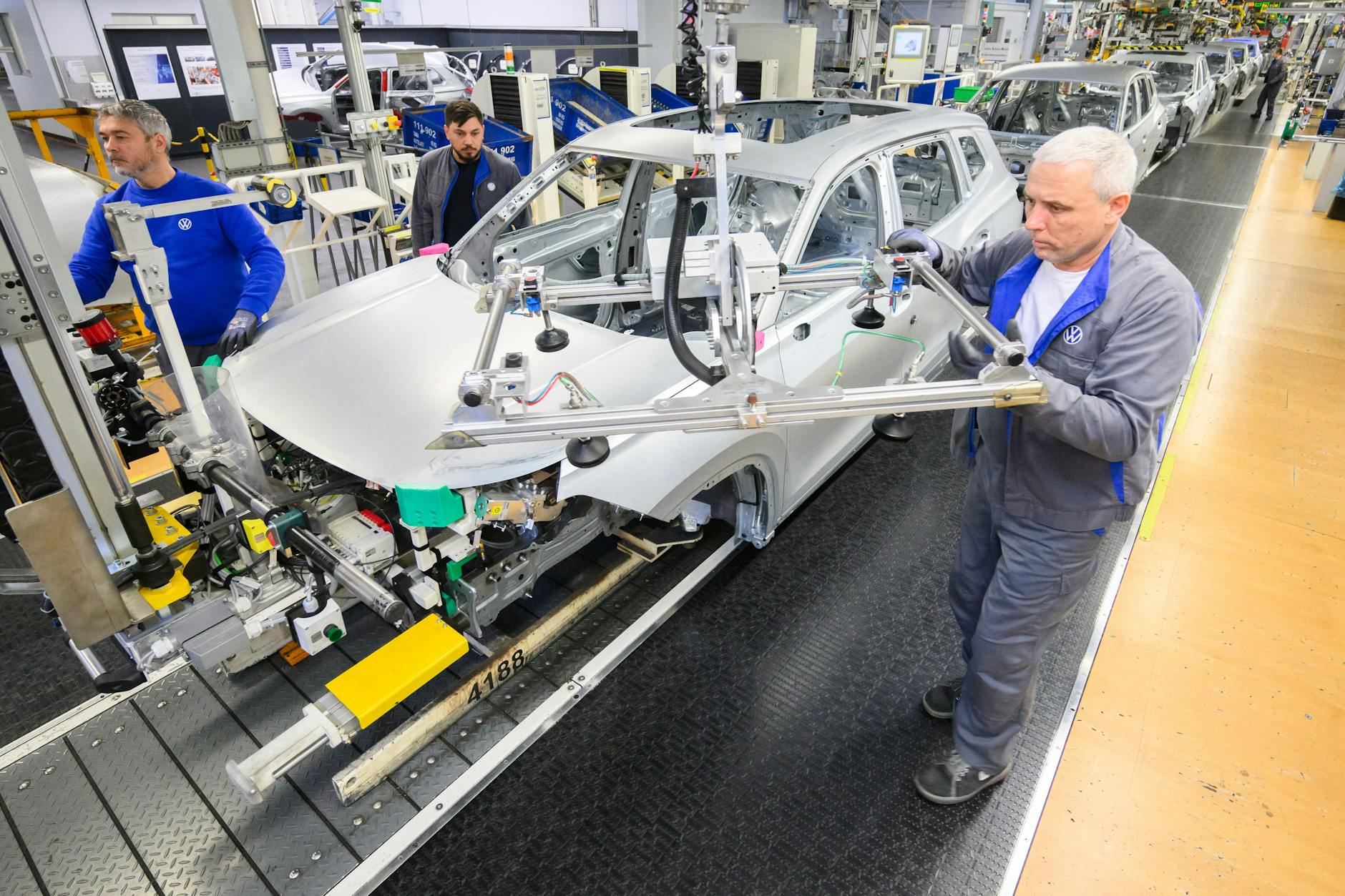 Mitarbeiter arbeiten im VW Stammwerk im Karosseriebau.