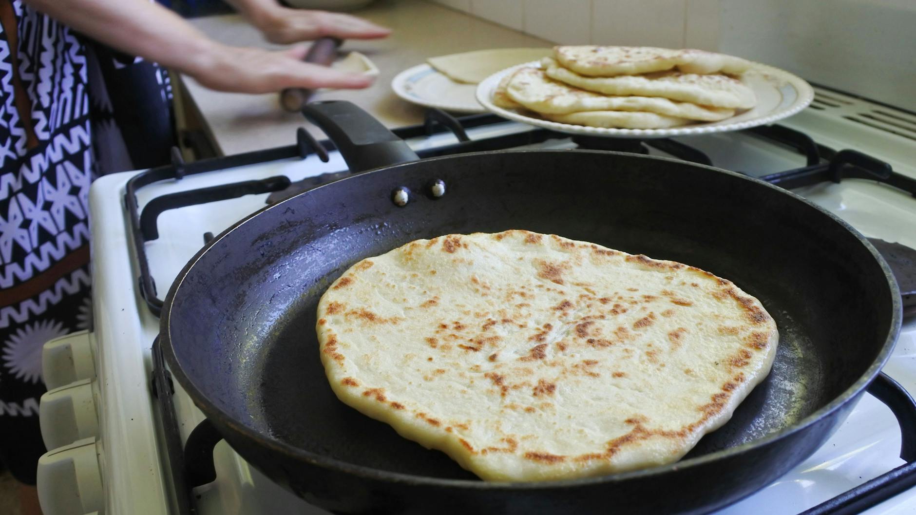 Die Teigstücke werden ausgerollt und dann in der Pfanne ausgebacken.