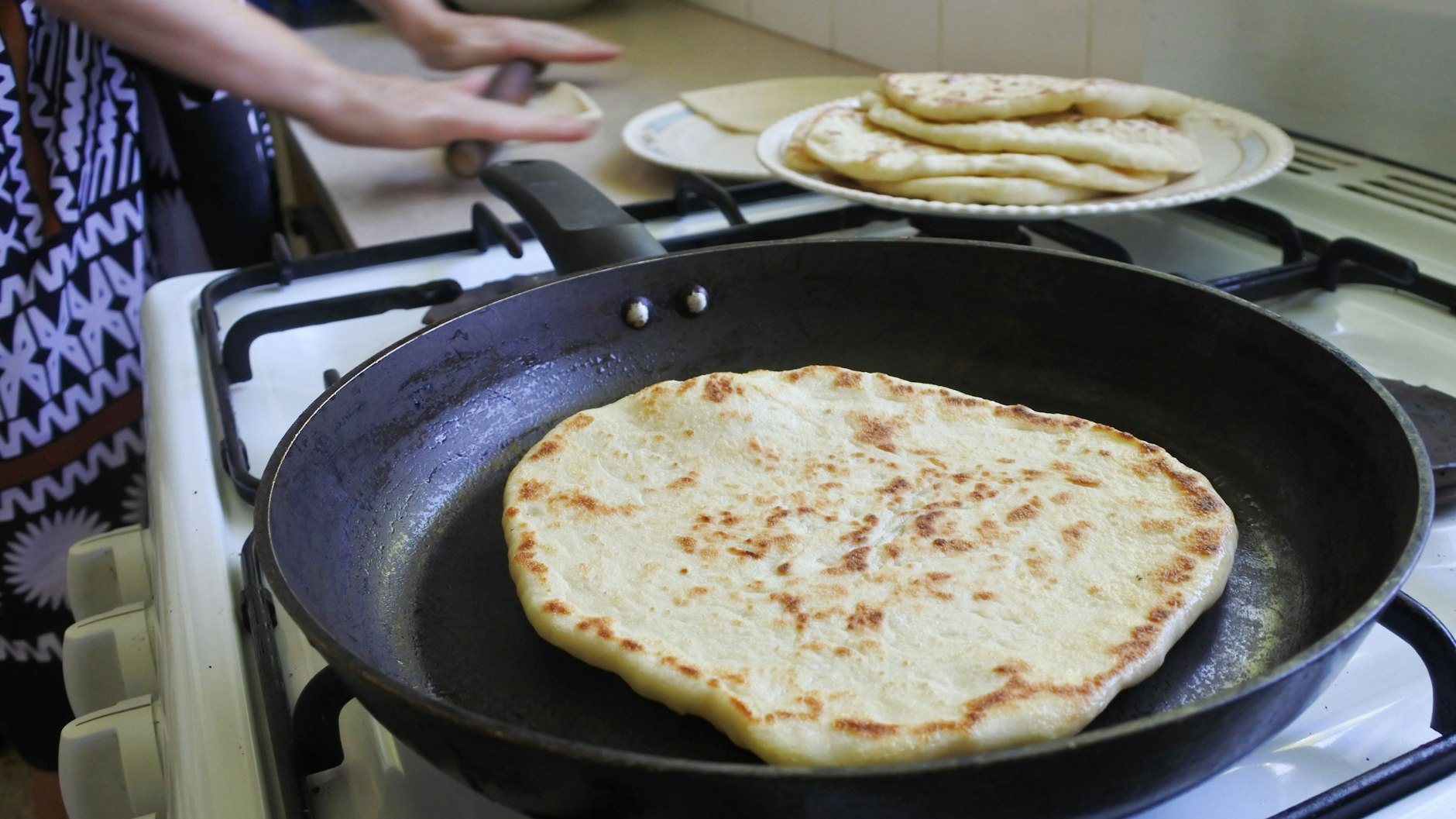 Die Teigstücke werden ausgerollt und dann in der Pfanne ausgebacken.