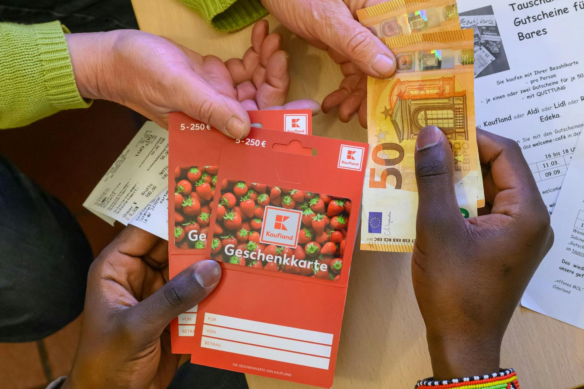 Im Willkommens-Café für Geflüchtete in einem Raum der Kirche von Seelow tauscht ein junger Mann aus Afrika Gutscheine gegen Bargeld.