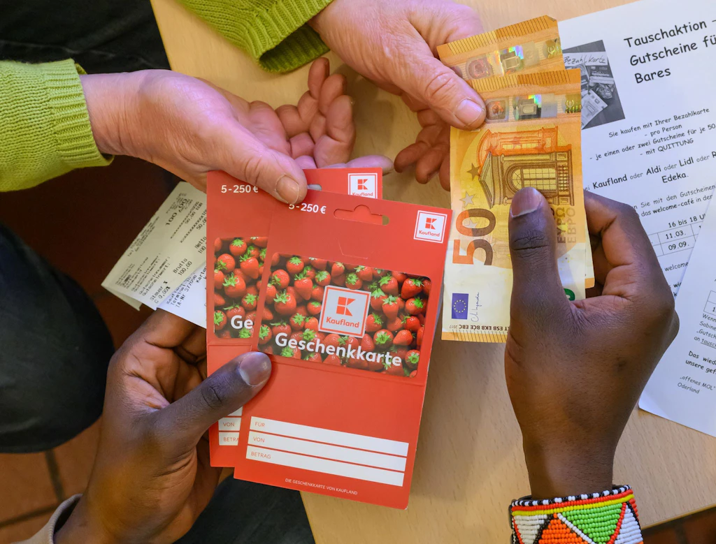 Bezahlkarte: Flüchtlinge kaufen Gutscheine und tauschen sie gegen Bargeld