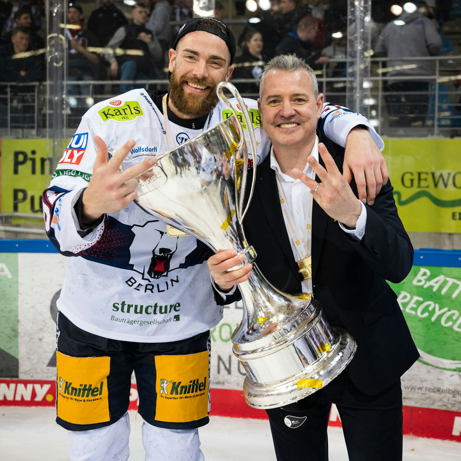 Wie 2024 wollen Marcel Noebels (l.) und Trainer Serge Aubin mit dem Meisterpokal jubeln. Nur wollen beide dann anstatt drei Finger vier zeigen ...