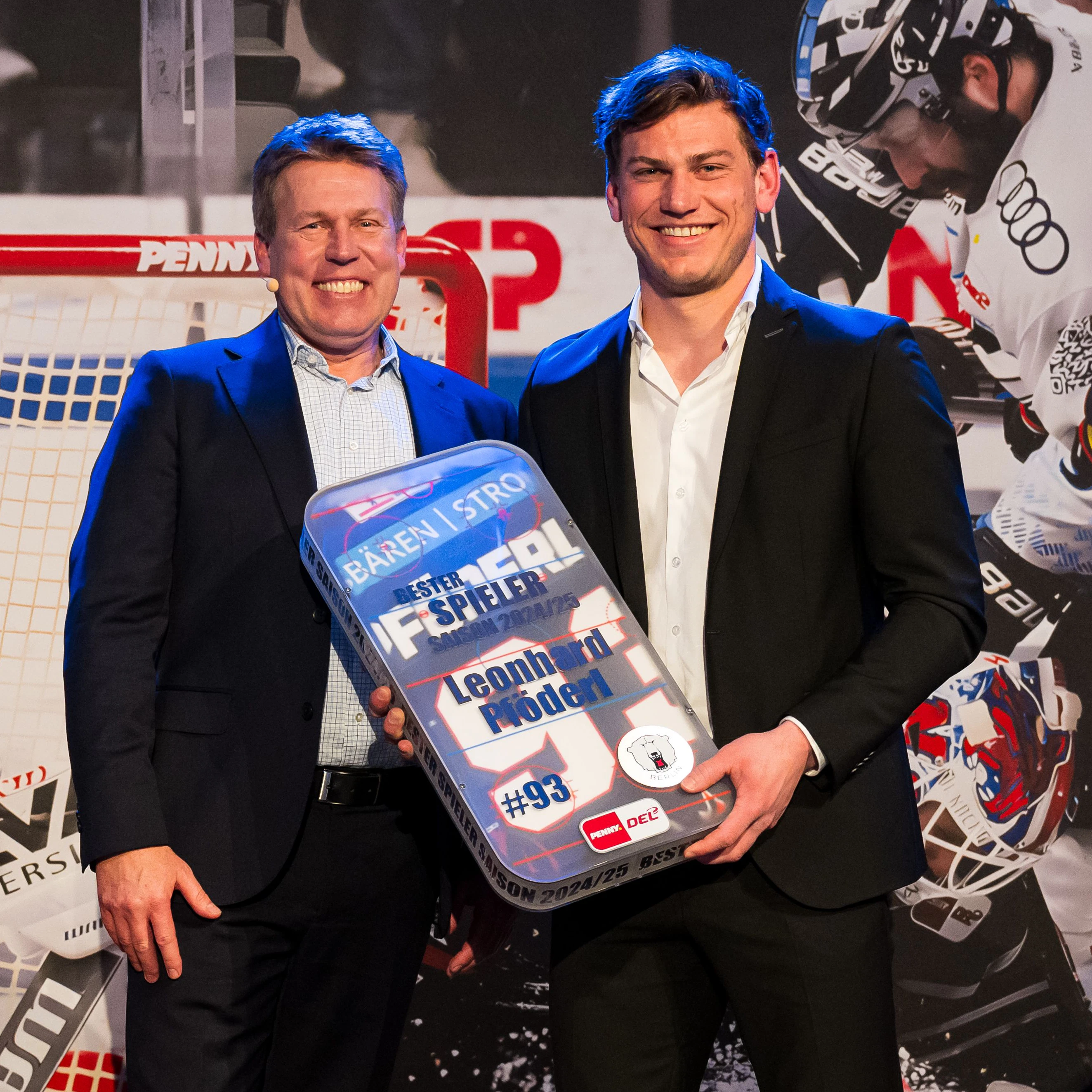 Leo Pföderl ist stolz wie Bolle, als ihn DEL-Geschäftsführer Gernot Tripcke (l.) als besten Spieler der Saison 2024/25 auszeichnet.