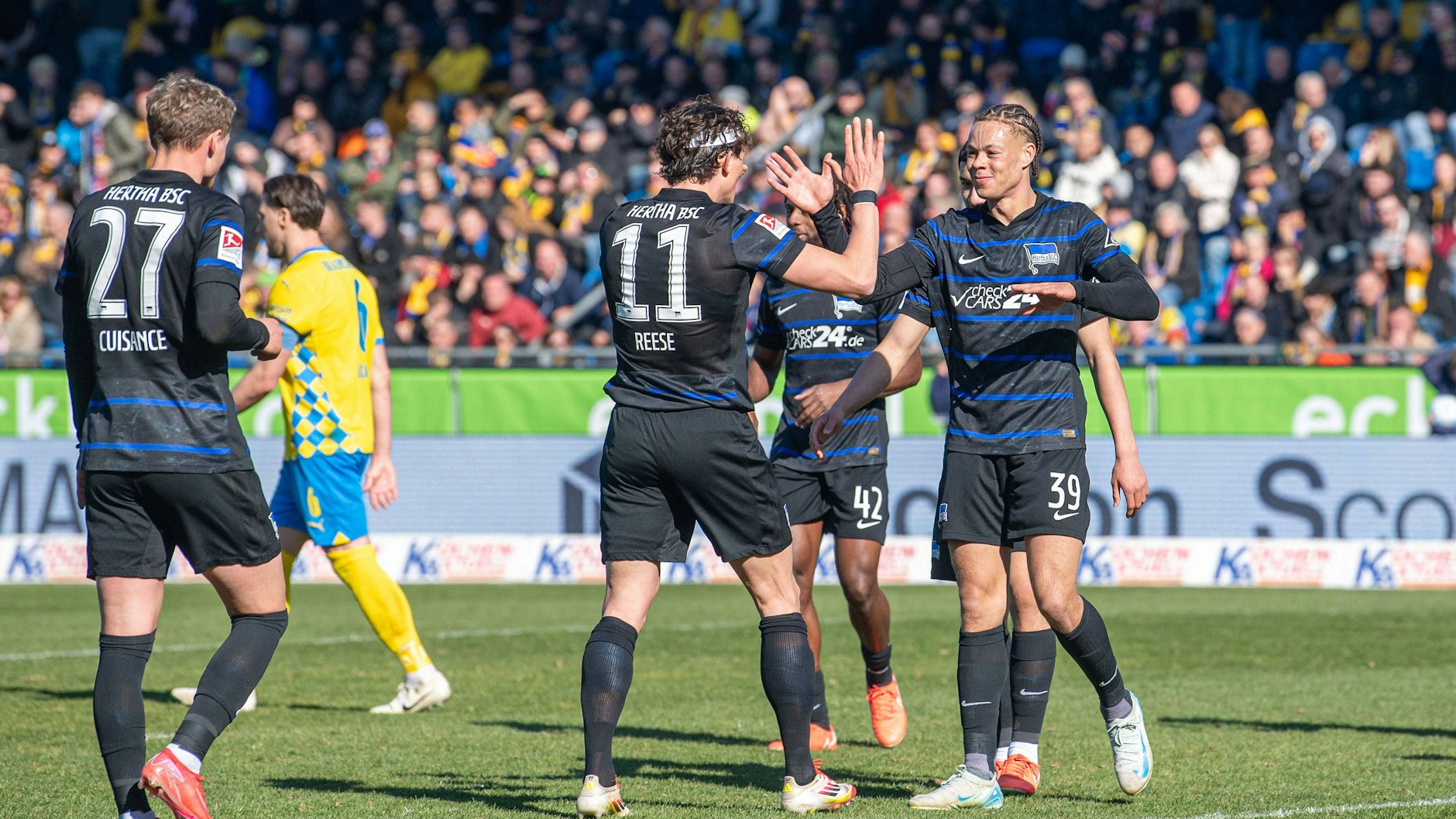 Michael Cuisance, Fabian Reese und Derry Scherhant feiern das 3:0 für Hertha BSC in Braunschweig.