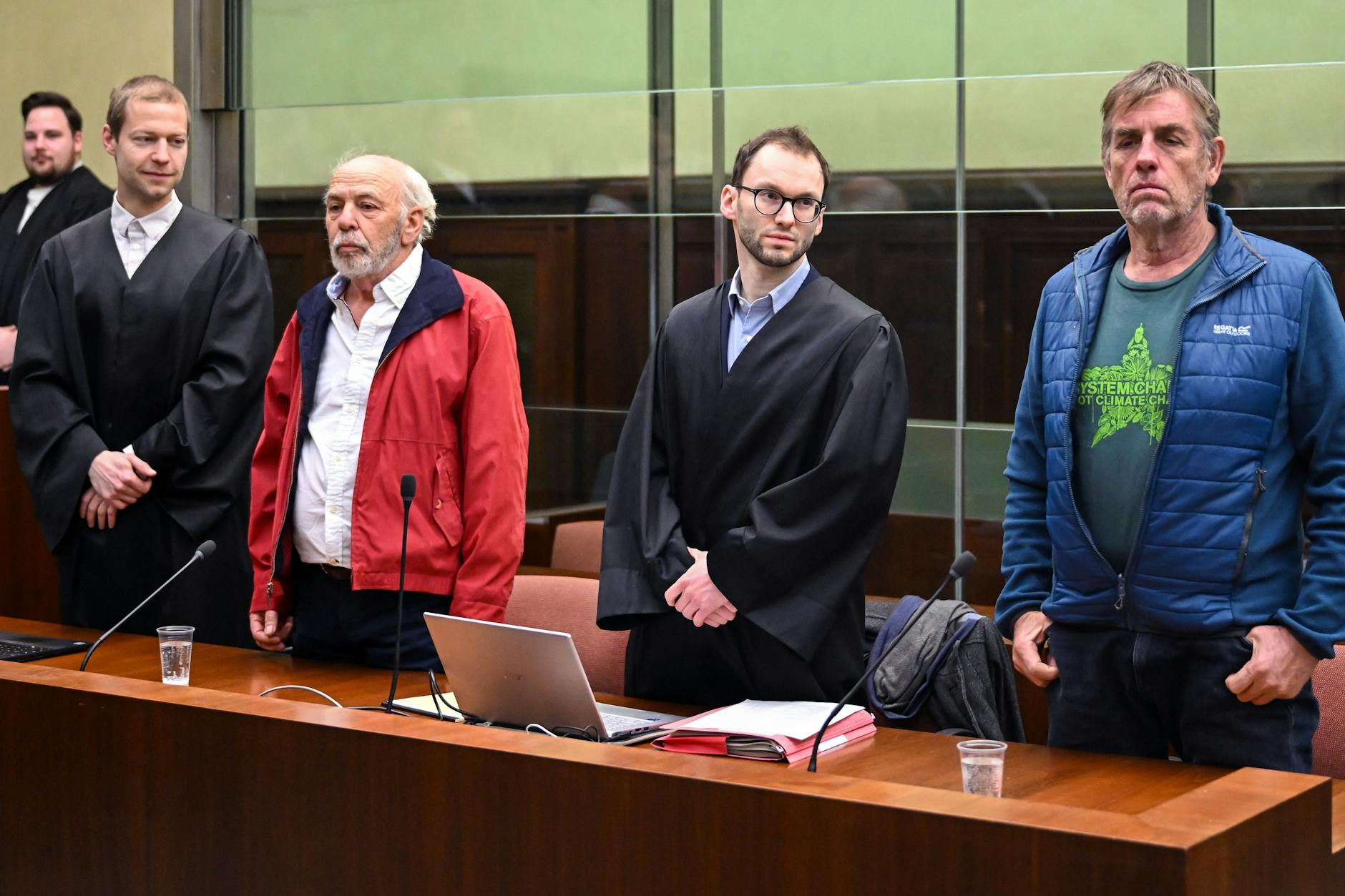 Die Angeklagten Peter K. (2.v.l.) und Thomas W. (r) mit ihren Verteidigern Lukas Theune (l.) und Benjamin Derin (2.v.r.). Am Ende des ersten Prozesstags sind die Angeklagten auf freiem Fuß.