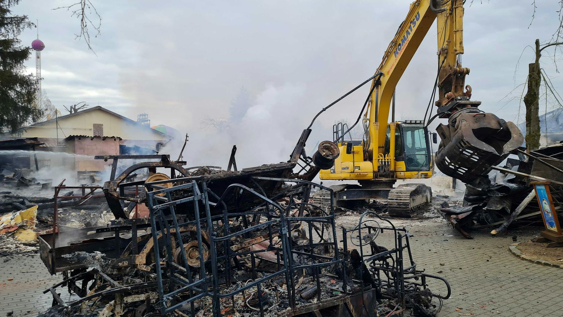 Eine von Feuer geschwärzte Metallkonstruktion steht neben einem Bagger. Keine zwei Wochen vor Saisonstart war im «Freizeit-Land Geiselwind» in Bayern ein Feuer ausgebrochen.