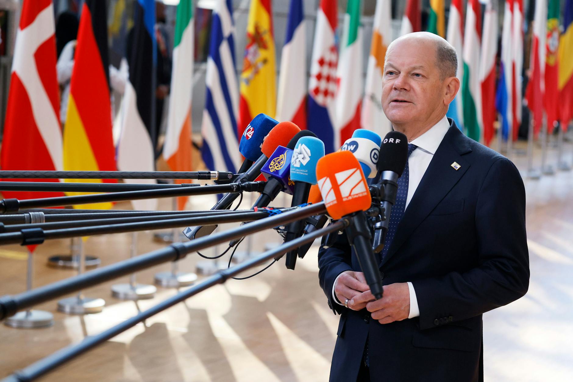 Belgien, Brüssel: Der deutsche Bundeskanzler Olaf Scholz (SPD) spricht mit Journalisten, als er zu einem EU-Gipfel im Gebäude des Europäischen Rates eintrifft.