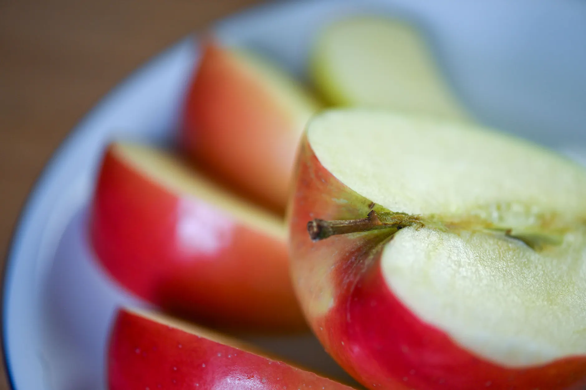 Ein aufgeschnittener Apfel liegt auf einem Obstteller.