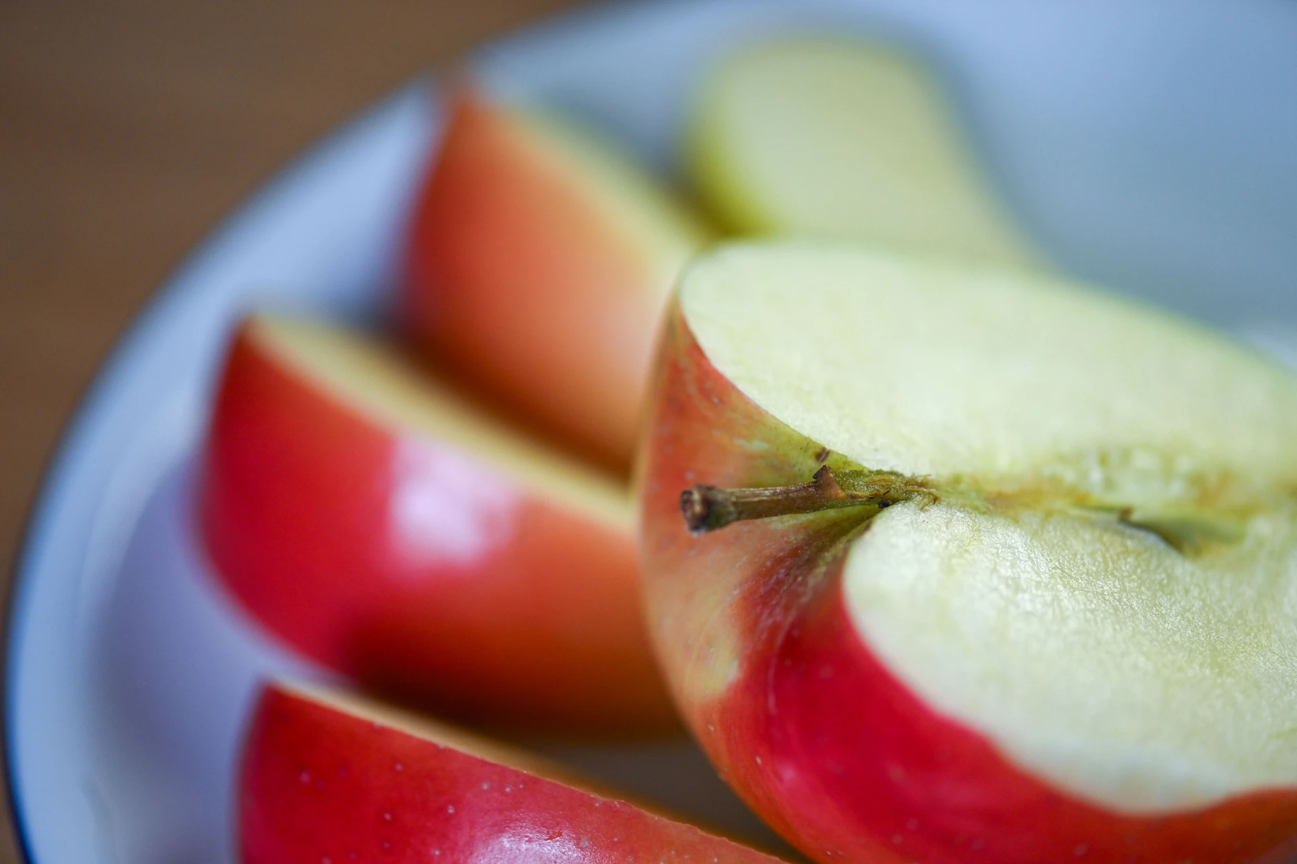 Ein aufgeschnittener Apfel liegt auf einem Obstteller.