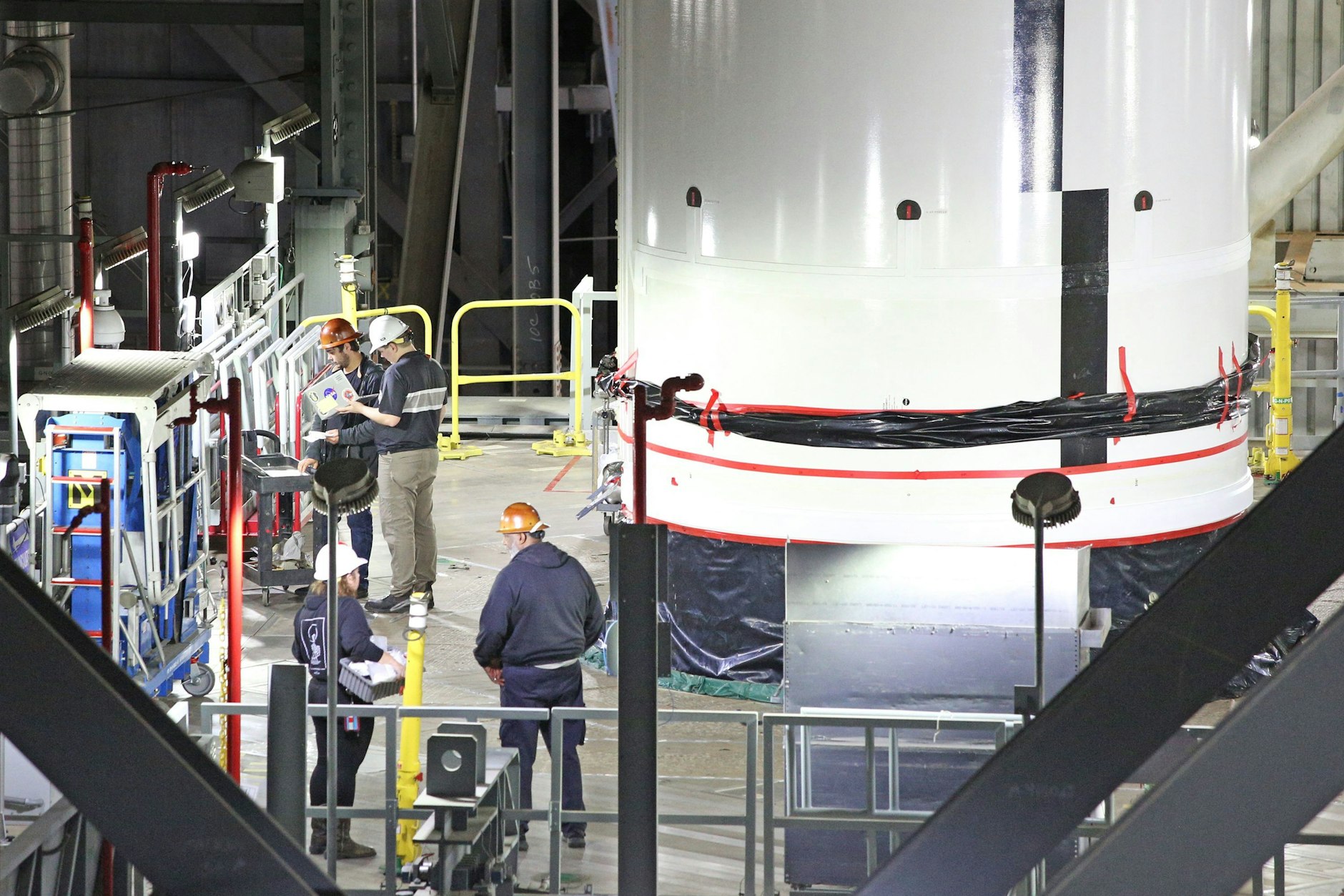 Nasa-Ingenieure arbeiten neben einem Feststoffraketen-Booster für das Artemis II Space Launch System (SLS) 