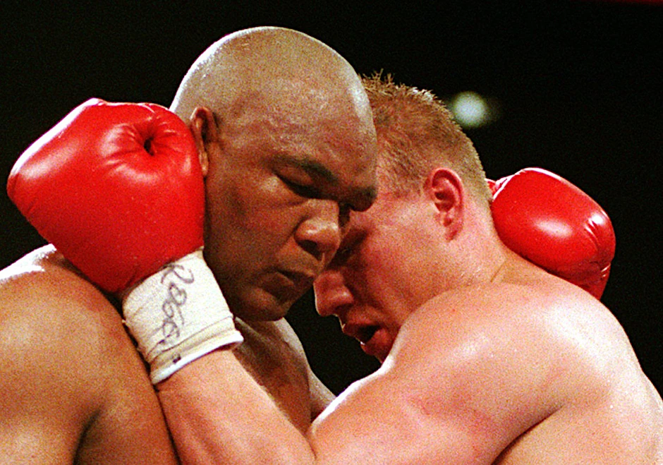 ARCHIV - 23.04.1995, USA, Las Vegas: Axel Schulz (r) und George Foreman im Clinch bei ihrem WM-Kampf in Las Vegas.