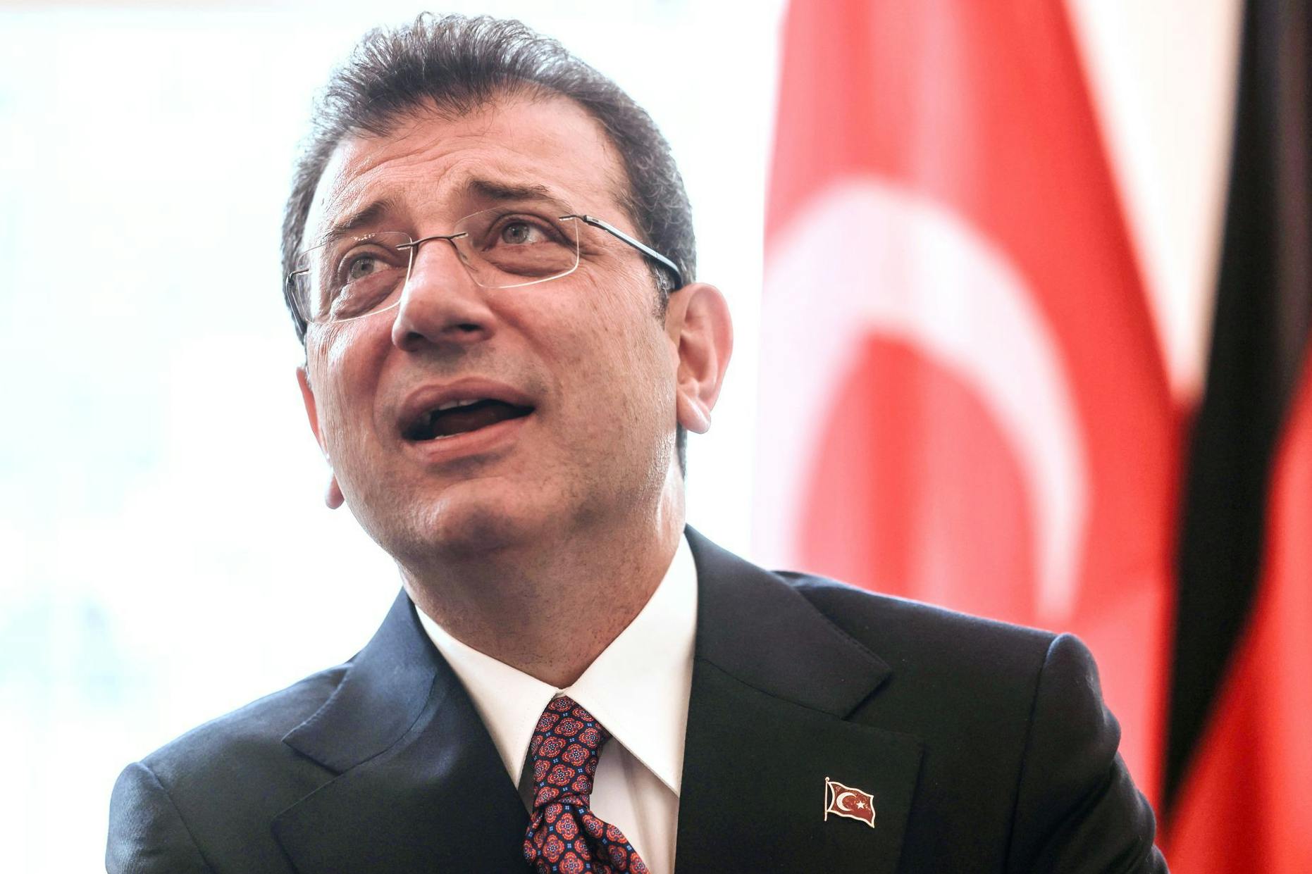 Ekrem İmamoğlu, Oberbürgermeister von Istanbul, steht bei einem Empfang im Rathaus vor einer türkischen Fahne.