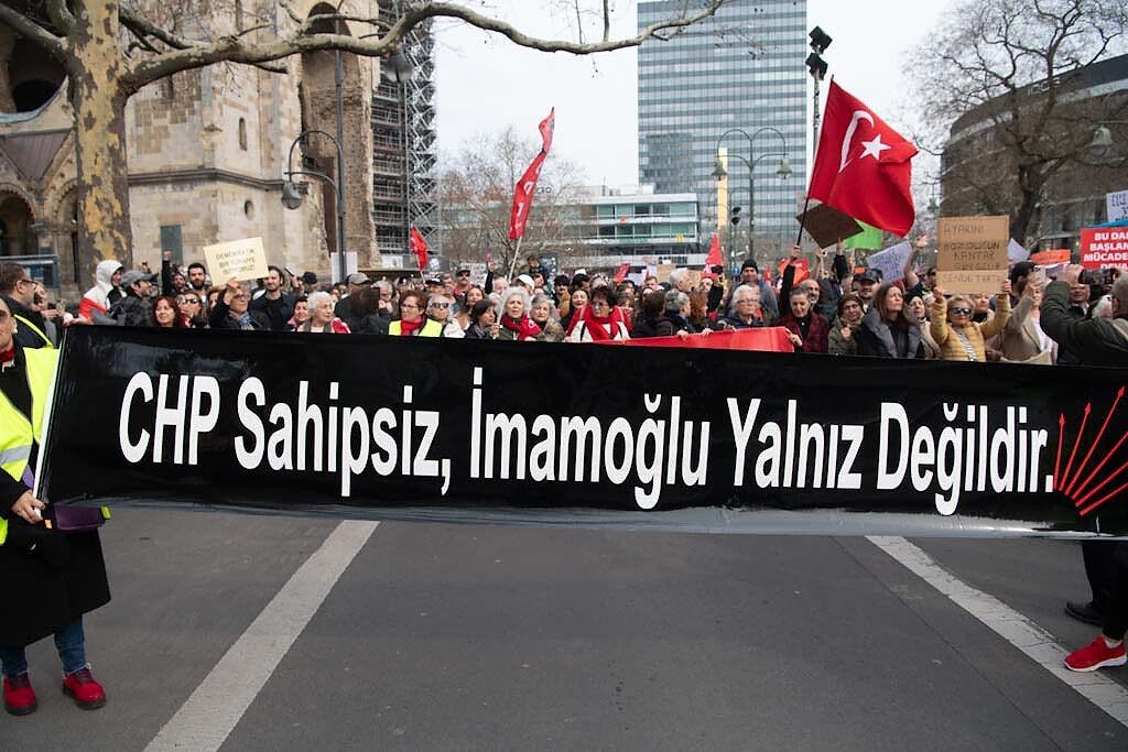 Mit türkischen Fahnen und Plakaten stehen Demonstranten am Breitscheidplatz bei einer Kundgebung des CHP Bund in Berlin.