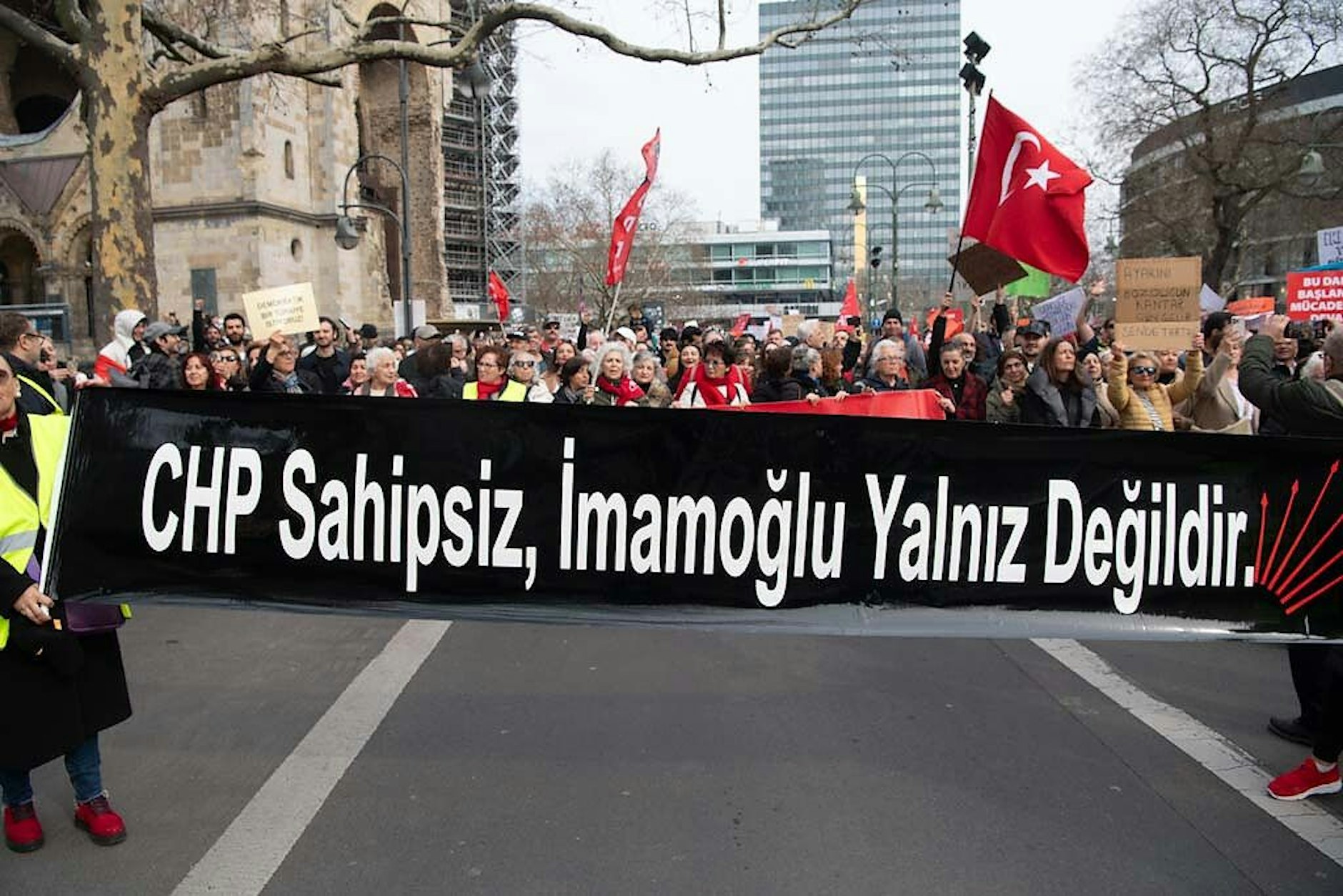 Mit türkischen Fahnen und Plakaten stehen Demonstranten am Breitscheidplatz bei einer Kundgebung des CHP Bund in Berlin.