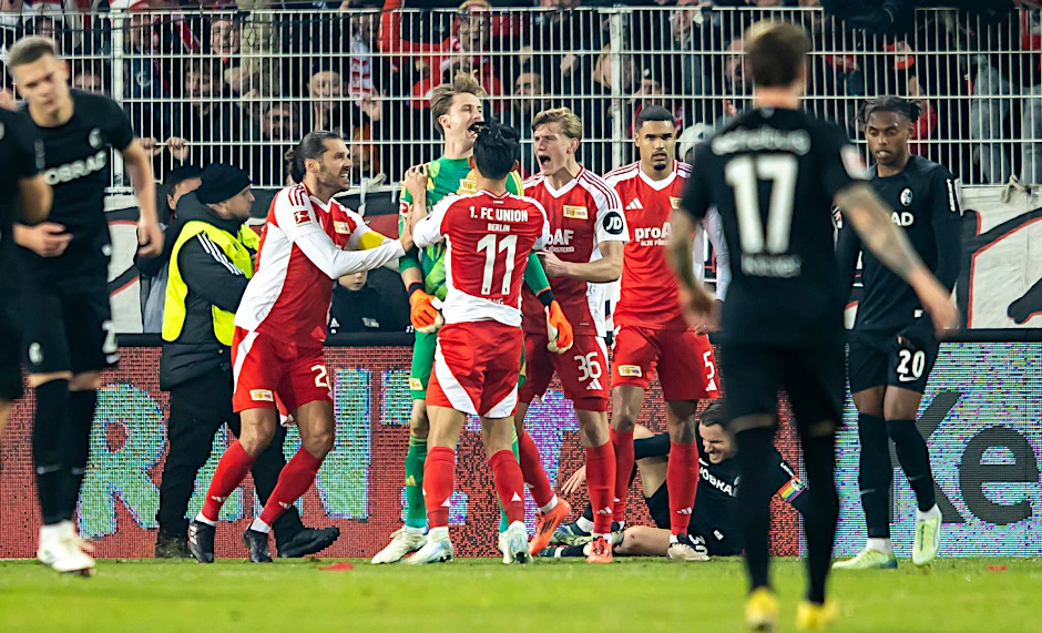 Die Spieler des 1. FC Union jubeln mit Torhüter Frederik Rönnow (Mitte) nach dessen gehaltenem Strafstoß.