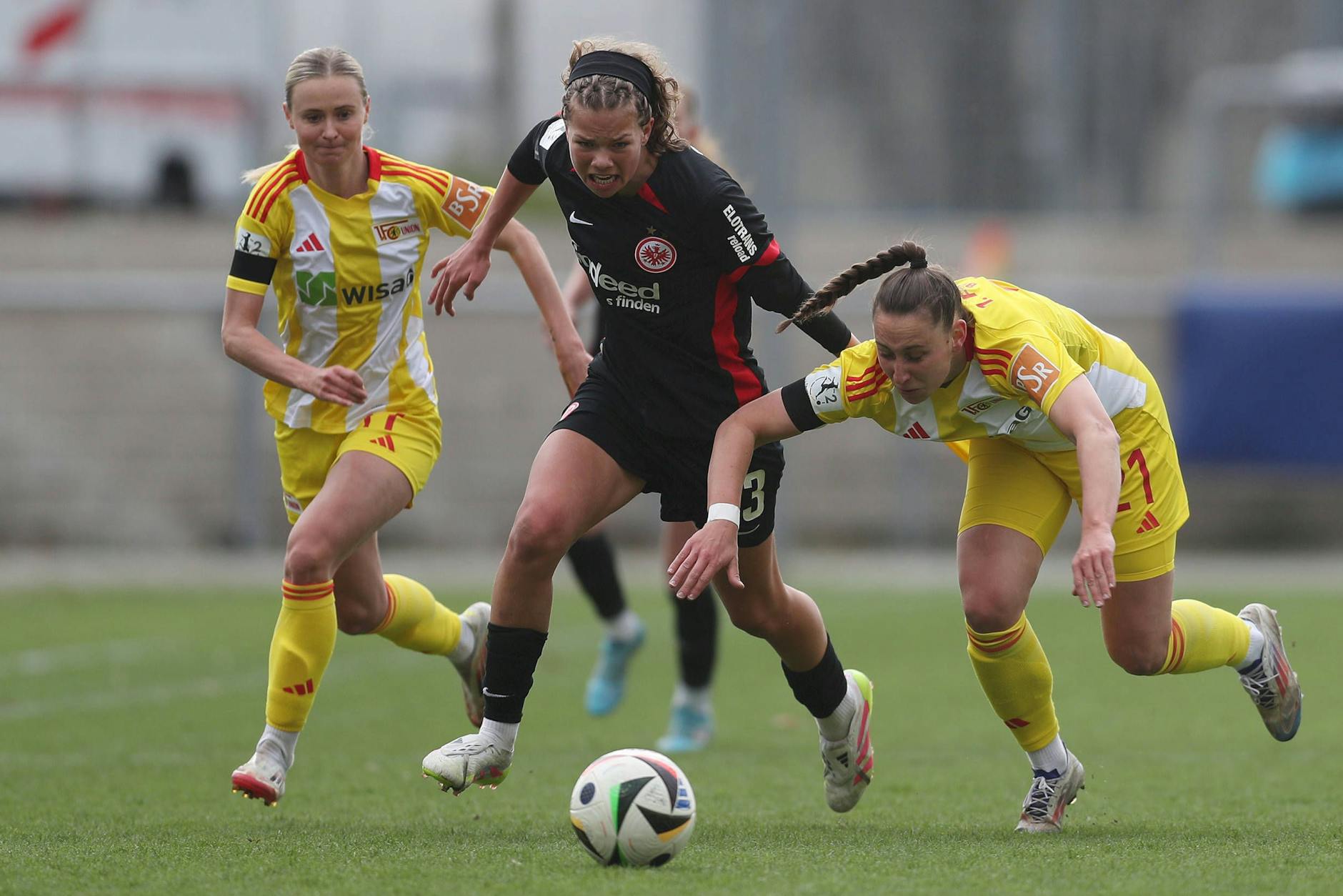 Judith Steinert (l.) und Anna Weiß vom 1. FC Union Berlin versuchen, die Frankfurter Angreiferin Rosa Rückert aufzuhalten.