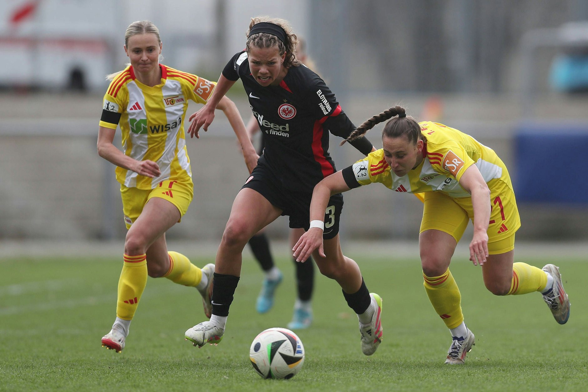 Judith Steinert (l.) und Anna Weiß vom 1. FC Union Berlin versuchen, die Frankfurter Angreiferin Rosa Rückert aufzuhalten.