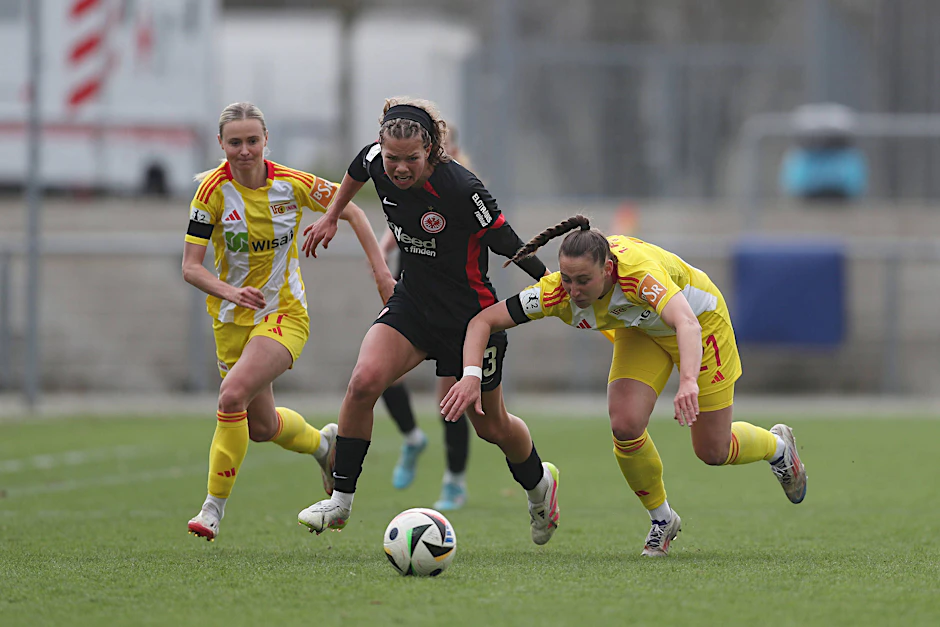 Judith Steinert (l.) und Anna Weiß vom 1. FC Union Berlin versuchen, die Frankfurter Angreiferin Rosa Rückert aufzuhalten.