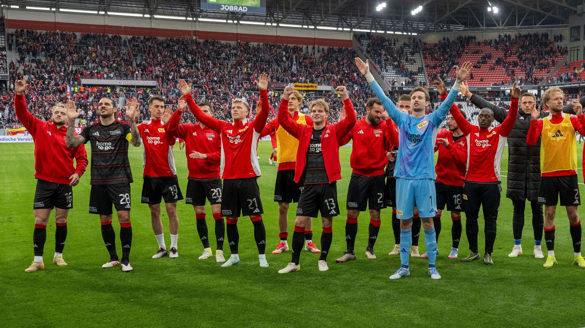 Die Spieler des 1. FC Union feiern nach dem Abpfiff in Freiburg ihren 2:1-Sieg vor der Fan-Kurve.