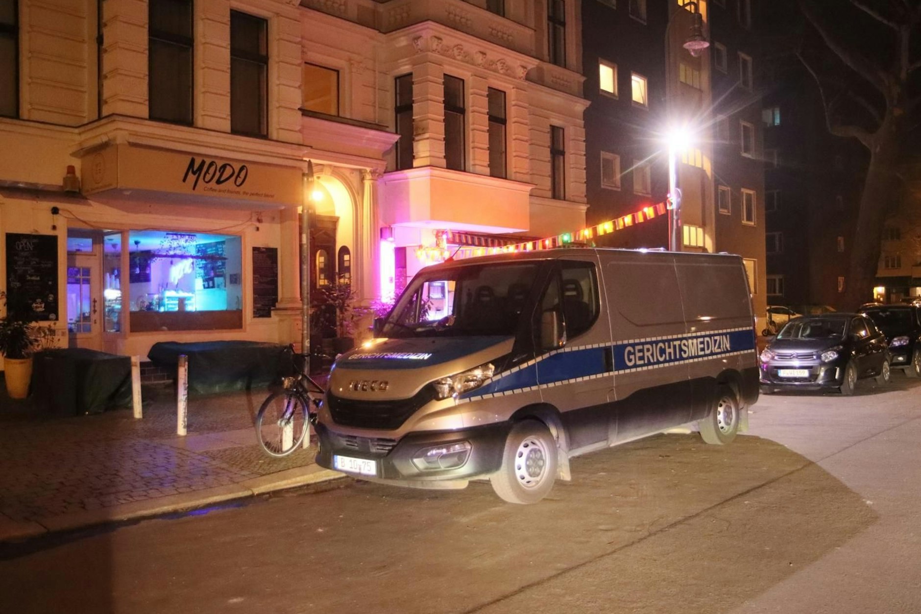 Ein Wagen der Gerichtsmedizin steht in der Fuggerstraße, wo ein Mann tot in einer Wohnung gefunden wurde.