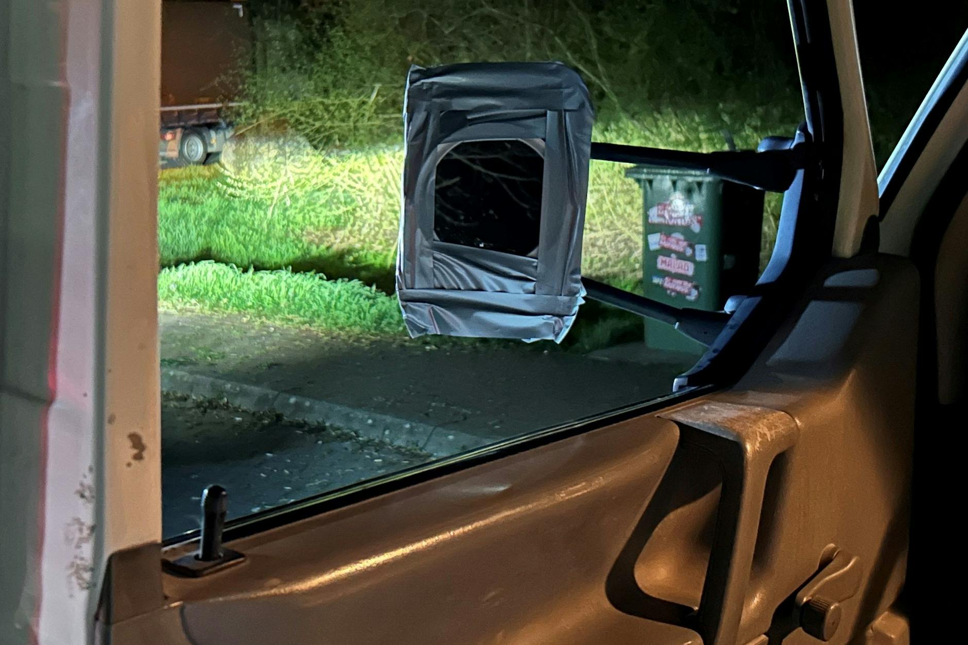 Durch das Fenster des Transporters, das keine Scheibe hat, der Blick auf den Rückspiegel, der eigentlich ein Kosmetikspiegel ist.