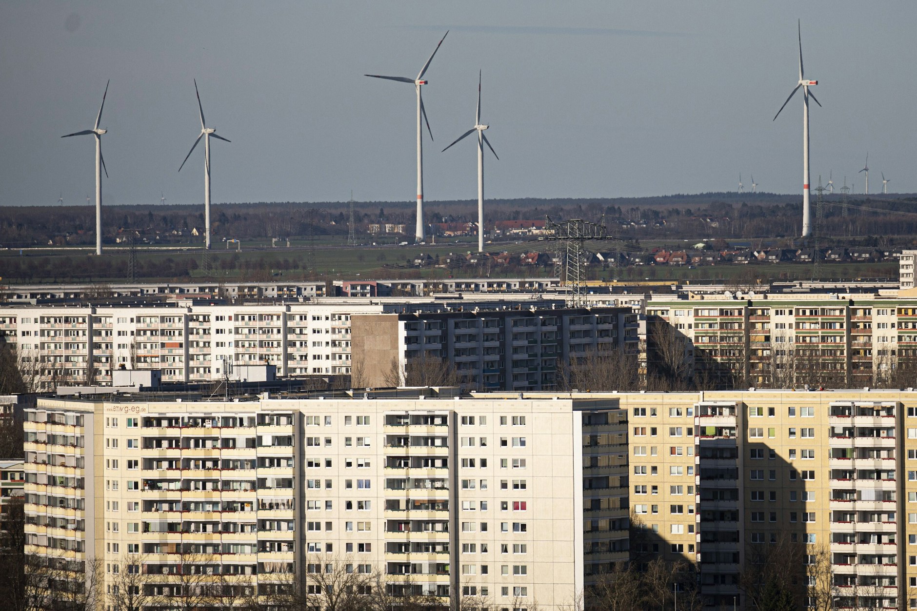 Windräder hinter Berliner Hochhäusern.