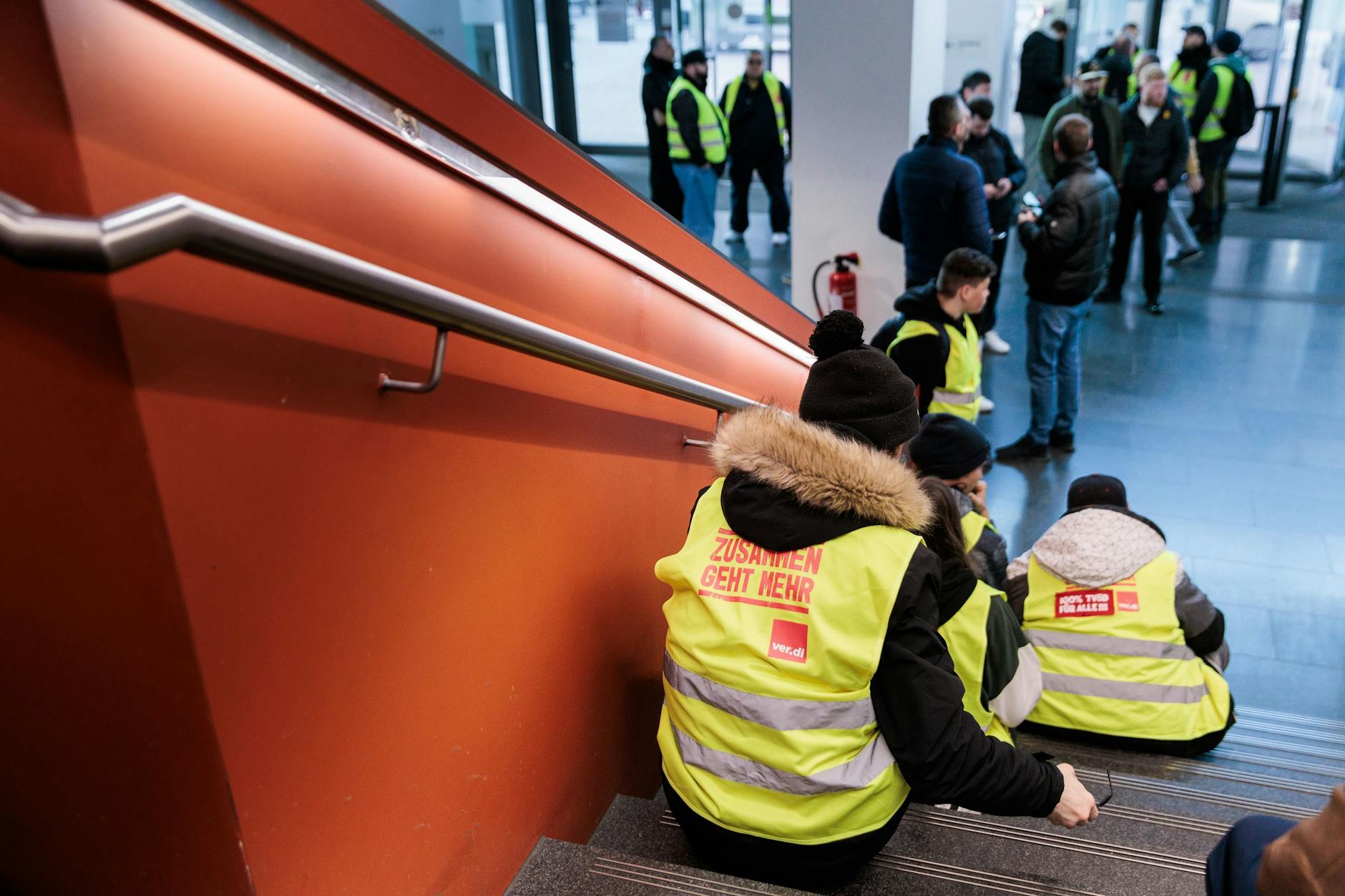 Mitarbeiter der Charité Facility Management (CFM) versammeln sich am 2. April 2025 zum unbefristeten Streik im Eingangsbereich eines Charité-Gebäudes.