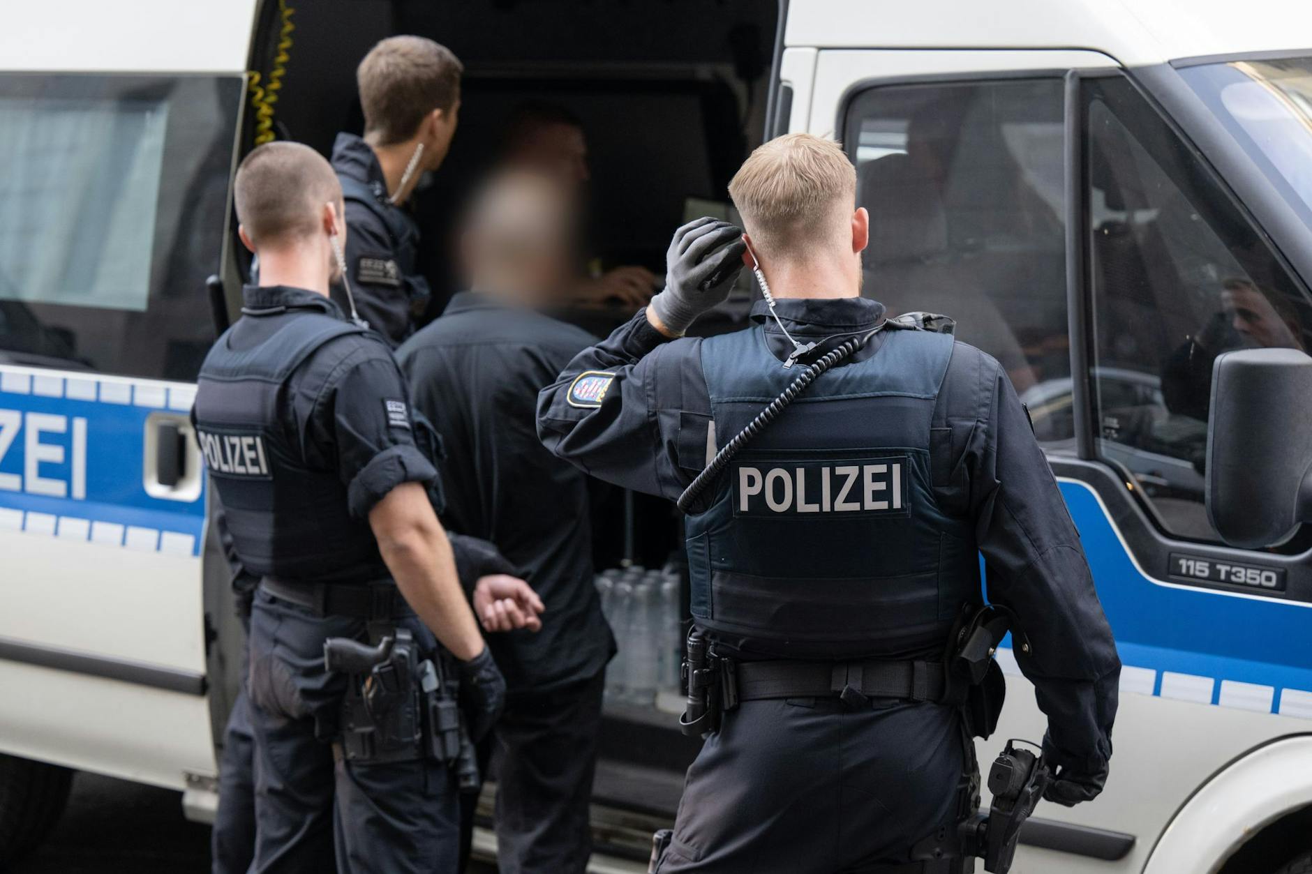 Polizisten führen in einem Kriminalitäts-Brennpunkt während einer Kontrollaktion einen Mann zur Personalienkontrolle.